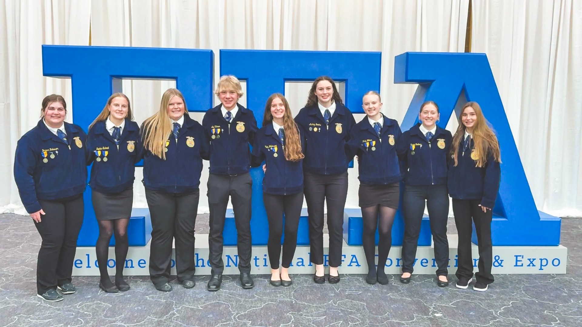 JCC FFA members in front of the large FFA sign at National Convention
